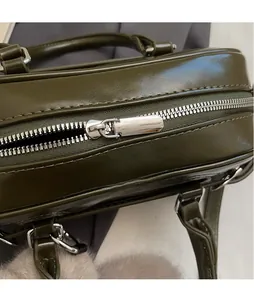 Vue détaillée du zip en métal argenté sur un sac à main en cuir vert olive