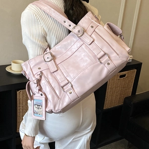 Dettaglio della borsa tote rosa in ecopelle con fibbie argentate e design multitasche