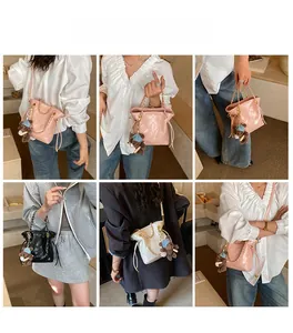 Sac seau matelassé avec chaîne et ours en peluche présenté dans divers styles de porté