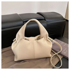 Detailed close-up of cream-white cloud handbag with pleated leather texture and shoulder strap