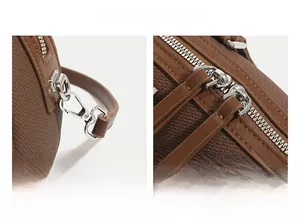 Détails des doubles fermetures éclair argentées et boucles métalliques sur sac en cuir brun