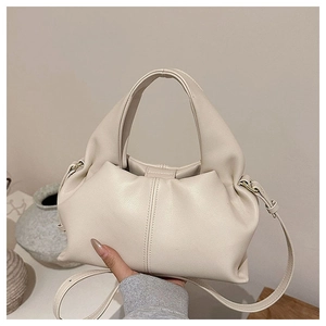 Detail of a creamy beige cloud-style pleated crossbody bag with a soft PU leather texture