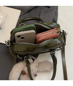 Vue intérieure du sac à main en cuir verni vert foncé montrant l'espace de rangement