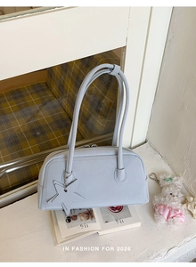 Detail of light blue rectangle shoulder bag with a star charm on a white windowsill