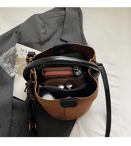 Gros plan de l'intérieur du sac seau en daim marron montrant sa grande capacité utile