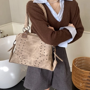 Vue détaillée du sac cabas kaki avec rivets métalliques et boucles de sangle renforcées