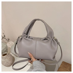 Detail of lavender pleated dumpling bag showing soft leather texture and handle