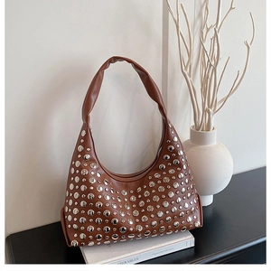 Detail der braunen Vintage-Achseltasche mit dekorativen silbernen Metallnieten verzierung