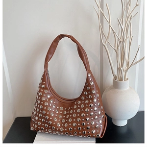 Detail einer dunkelbraunen Hobo-Tasche aus Leder mit Nieten und eleganter Mondform