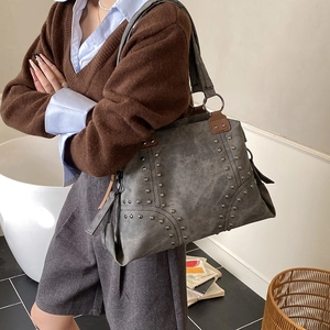 Gros plan sur un sac cabas rétro gris foncé avec des rivets décoratifs et doubles anses