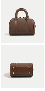 Détail du sac Boston montrant la texture du tissu marron et les pieds de protection