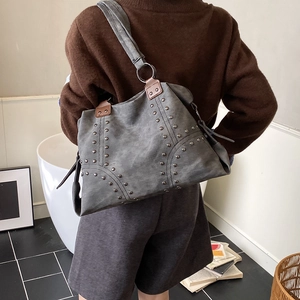 Détail du grand sac cabas vintage en cuir gris mat avec rivets métalliques et bandoulière