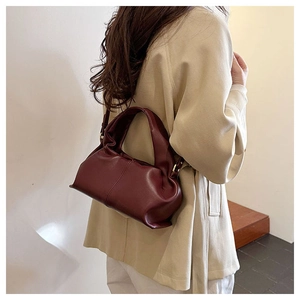 Detail of dark burgundy cloud bag showing soft pleated leather texture and metal D-ring