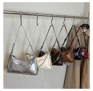 Sacs portés épaule brillants avec chaîne en plusieurs couleurs présentés en boutique
