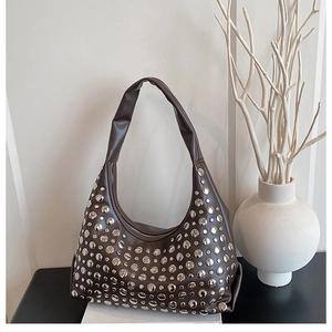 Detail der dunkelbraunen Hobo-Tasche mit dekorativen Silbernieten und Vintage-Lederstruktur