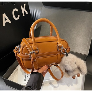 Detailed view of orange brown leather handbag in premium gift box with rabbit charm accessory