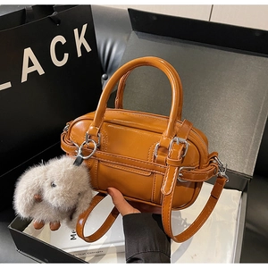 Detail view of vintage brown Boston bag with silver buckle and grey plush bunny charm