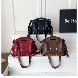Tre borse in pelle con borchie nei colori nero, bordeaux e marrone con lunghe frange