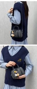Détail du mini sac Boston gris avec breloques étoile et chiot et poignées en cuir