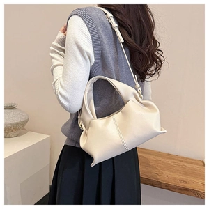 Close-up of soft beige cloud bag featuring fine lychee grain texture and vertical stitching