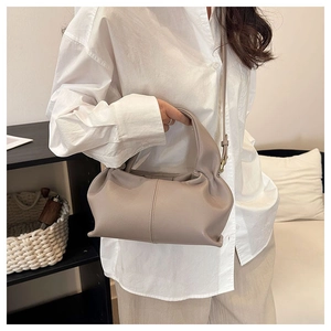 Close-up of taupe cloud bag with pleated leather texture and gold hardware details