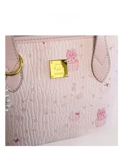 Dettaglio della borsa a secchiello rosa con motivi di gatti e placca logo dorata