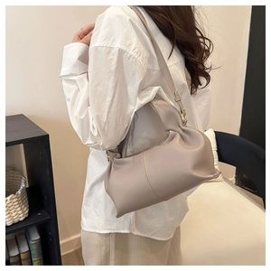Chic light gray pleated dumpling bag with adjustable shoulder strap on a model