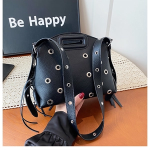 Dettaglio borsa moto nera con trama litchi, occhielli in argento e nappe di pelle