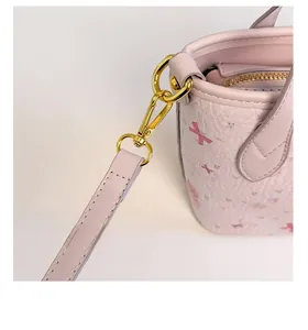 Dettaglio della borsa rosa in pelle martellata con hardware dorato e cuciture