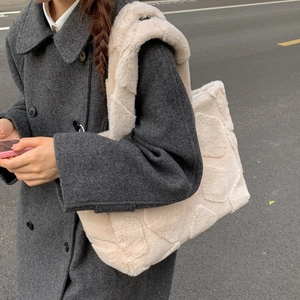 Detail of off-white plush tote bag with textured checkered pattern and wide shoulder strap