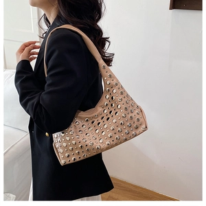 Detailansicht einer beigen Hobo-Tasche mit silbernen Nieten und breitem Schultergurt