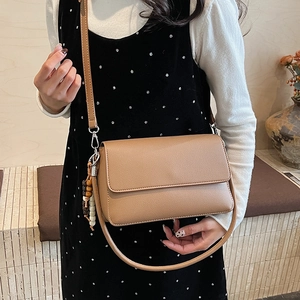 Sac à bandoulière classique en cuir grainé marron avec perles en bois sur mannequin