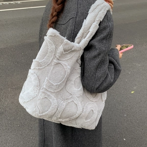 Detailed texture of grey plush tote bag with 3D round pattern on soft faux fur fabric