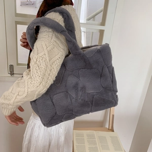 Detail of grey faux fur tote bag with quilted square texture and wide shoulder strap
