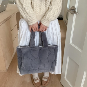 Detailed texture of grey plush tote bag featuring quilted petal pattern and soft handles