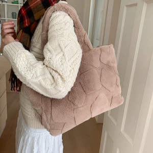 Plush tote bag with geometric texture shown on shoulder for autumn winter look