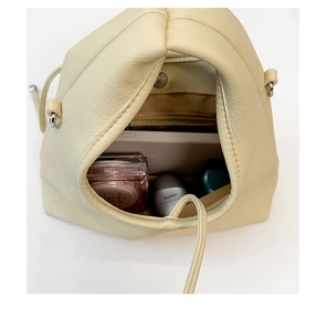Interior storage capacity of the cream leather handbag with magnetic snap and pocket