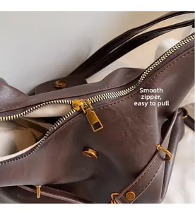 Close-up of smooth gold zipper and beige lining on a dark brown leather shoulder bag