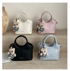 Sacs Chab'2nk en quatre couleurs avec pendentifs ours sur escaliers en pierre