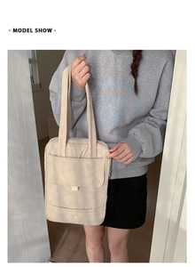 Detail of minimalist quilted beige crossbody bag with front pocket and shoulder strap