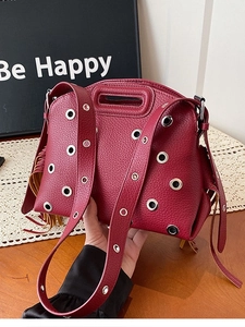 Borsa da moto bordeaux con borchie, occhielli argentati e nappine su base in legno
