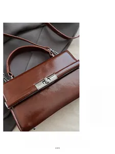 Detail of a brown glossy leather handbag with a silver rectangular metal twist lock