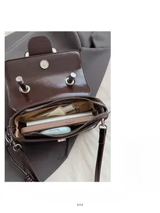 Deep brown glossy crossbody bag showing spacious interior with zipper pocket and metal lock