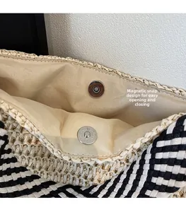 Detail of magnetic snap closure and woven texture on a casual straw tote bag