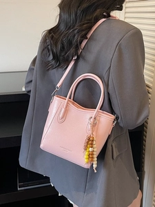Pink PU leather bucket bag with litchi texture and wooden bead charm accessory