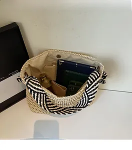 Spacious interior of beige straw tote bag with black and white striped handle