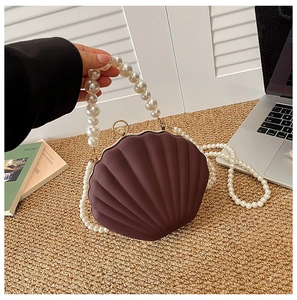 Detail of shell-shaped acrylic bag with matte texture and elegant pearl bead strap