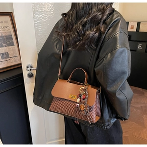 Détails du sac pied-de-poule marron avec fermoir rotatif doré et pendentif floral