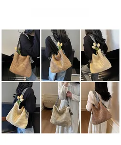 Detail view of large straw tote bags in beige and brown with striped fabric shoulder straps