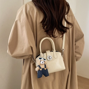 French vintage cream patent leather handbag featuring a silver twist lock and bear charm